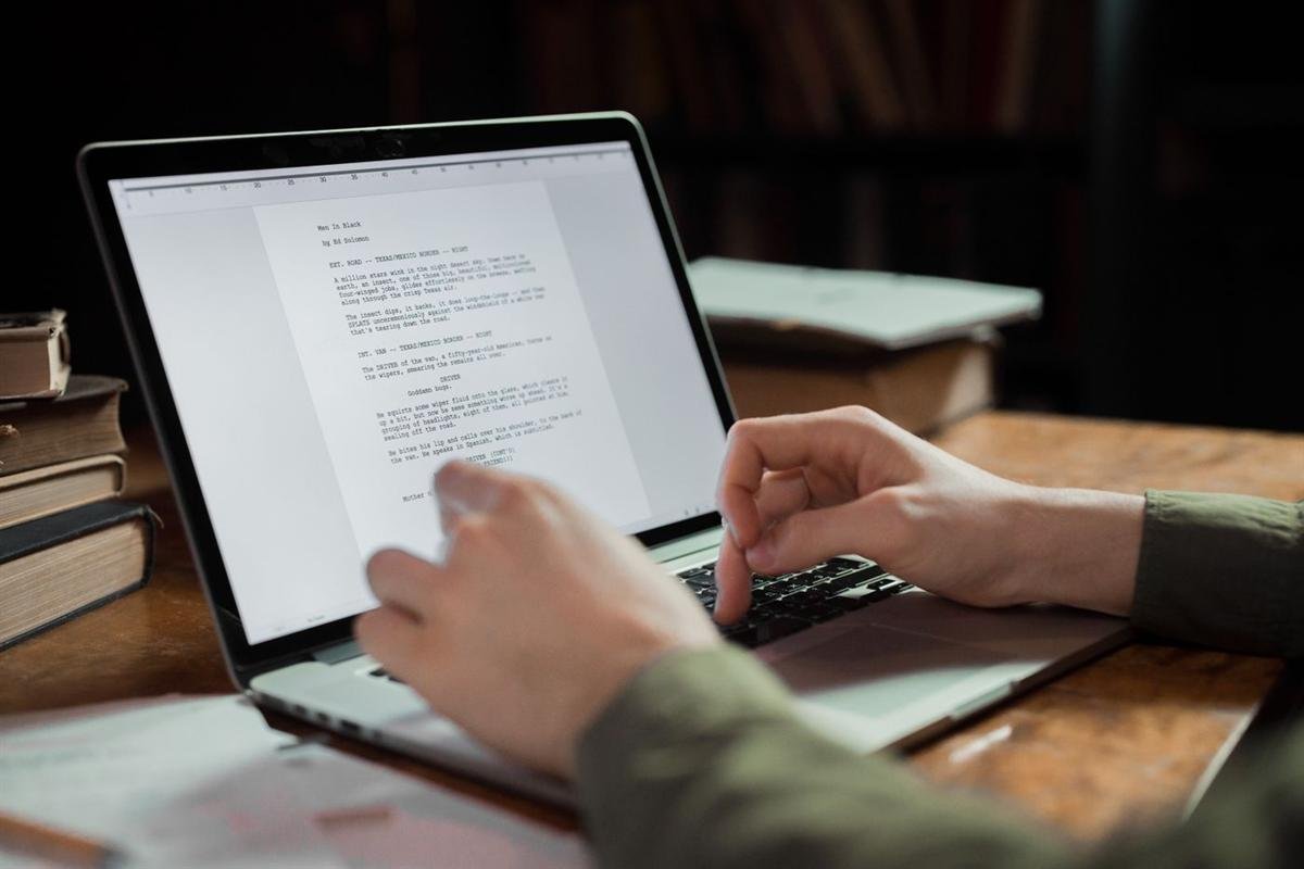 Person typing on a laptop in a cozy workspace surrounded by books