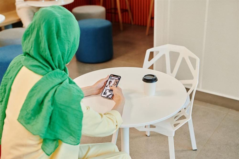 Woman scrolling on a smartphone at a cafe table