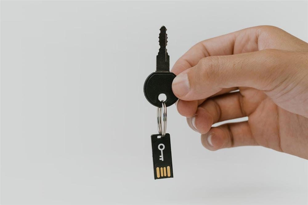 Hand holding a key attached to a USB drive