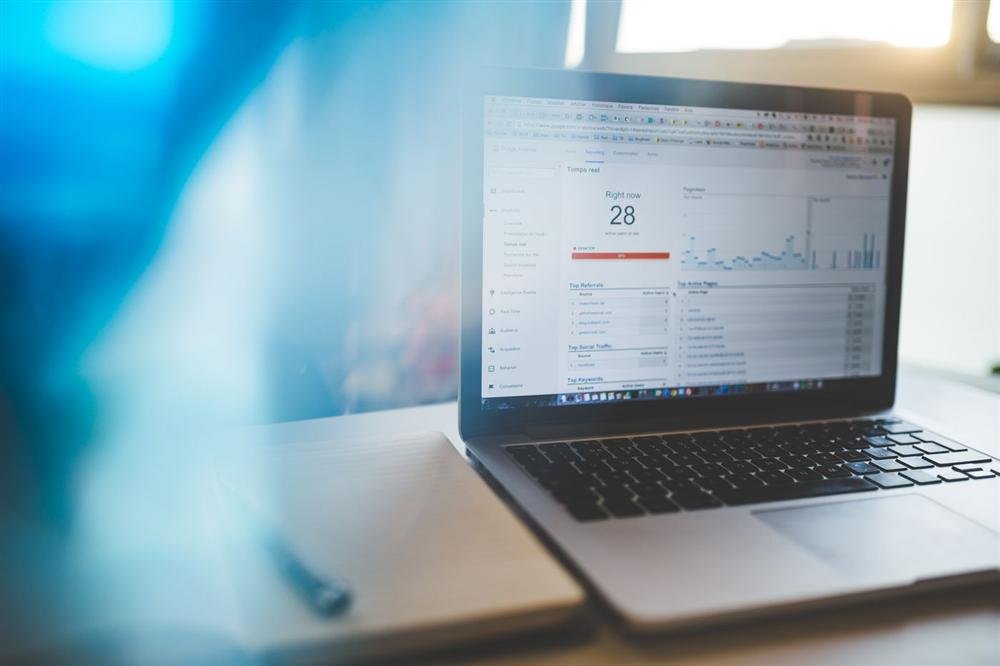 Laptop screen showing a Google Analytics dashboard in a modern workspace