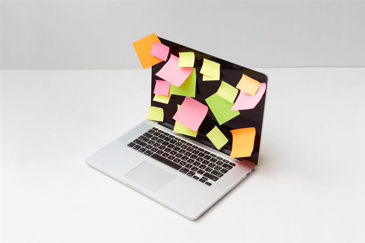 Laptop covered with colorful sticky notes for project planning