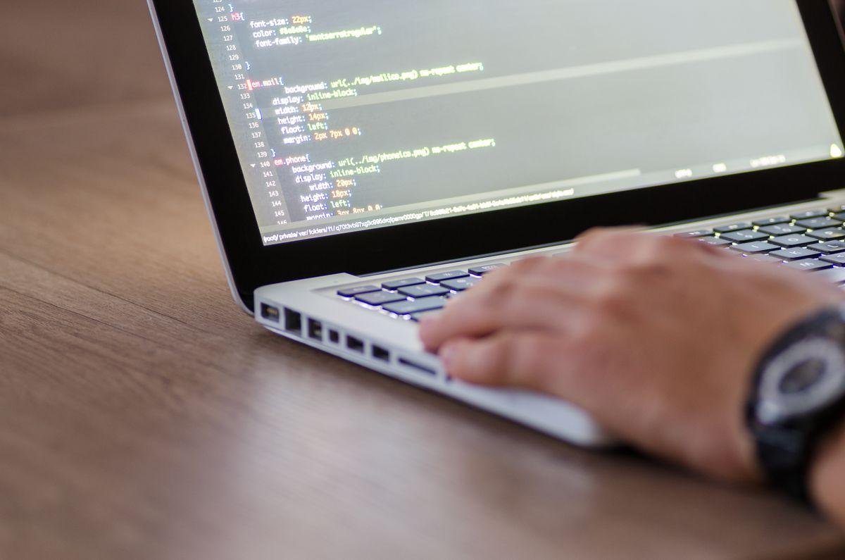 Developer writing website code on a laptop